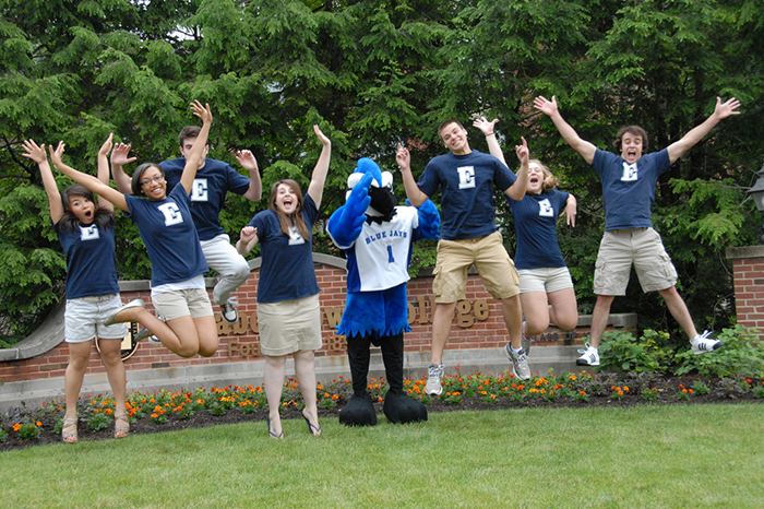 happy students jumping outside with Blue Jay Mascot