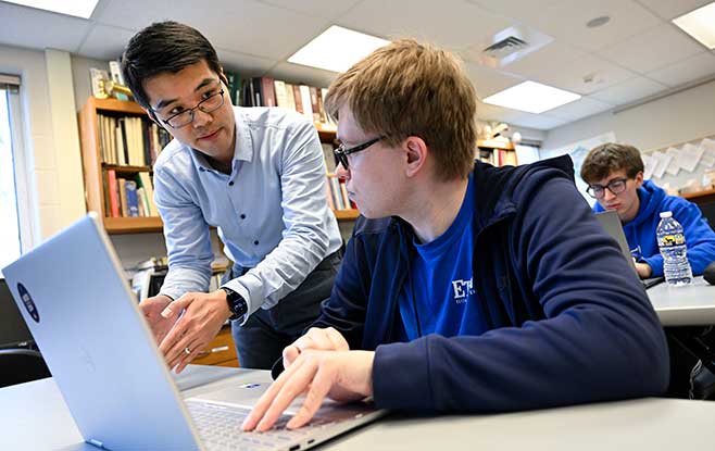 students in a classroom on a lapto